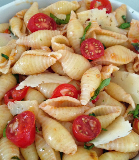Seashell pasta salad with basil, tomatoes, and garlic